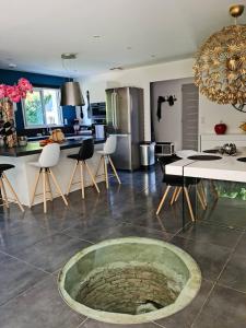 cocina y sala de estar con mesa y sillas en Maison contemporaine aux portes des cevennes, en Alès