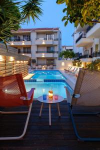 a patio with two chairs and a table and a swimming pool at Bourtzi Hotel in Skiathos