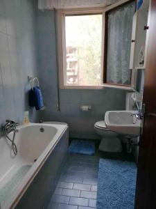 a bathroom with a tub and a toilet and a sink at Immobile Vintage a Grado Pineta in Grado-Pineta