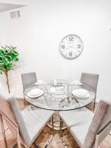 a glass table with chairs and a clock on the wall at Gaslamp 2bdrm - W Parking & 4 Beds #404 in San Diego