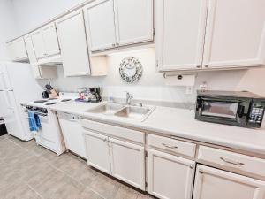a kitchen with white cabinets and a sink at Gaslamp 2bdrm - W Parking & 4 Beds #404 in San Diego