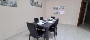 a black table with black chairs and plates on it at Large Apartment in Marsascala. sleeps 6 in Marsaskala