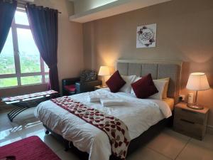 a bedroom with a large bed and a large window at The Viana Apartment 1 in Kota Bharu