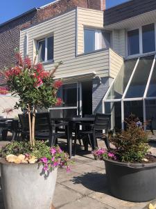 patio ze stołem, krzesłami i kwiatami w obiekcie Vakantiewoning De Kassei Geraardsbergen max 12personen w mieście Geraardsbergen