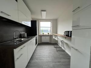 a kitchen with white cabinets and a sink and a window at "Live Good, Work Good"- Central Apartment by GG Rental Hamburg in Hamburg