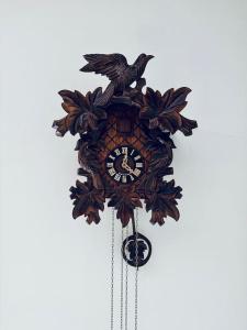 une horloge en bois avec deux oiseaux au-dessus dans l'établissement Hunter's lodge Oliver, à Křimov