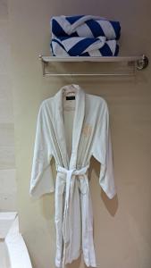 a white robe is hanging on a wall at Slipi Apartment 2BR in Jakarta