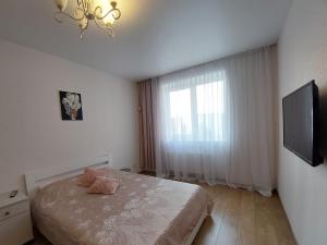 a bedroom with a bed with a television and a window at Новобуд з кондиціонером ЖК "Яровиця 11" in Lutsk