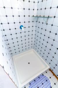 a white tiled shower with a white toilet in a bathroom at Titicaca tikary's lodge in Puno