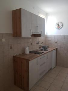 uma cozinha com armários brancos e um lavatório em Apartments by the Sea em Lopar