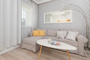 uma sala de estar com um sofá e uma mesa em Italian-style Apartment in the "Tesoro Gardens" by Renters em Gdynia