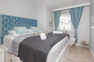 um quarto com uma cama grande e uma cabeceira azul em Italian-style Apartment in the "Tesoro Gardens" by Renters em Gdynia
