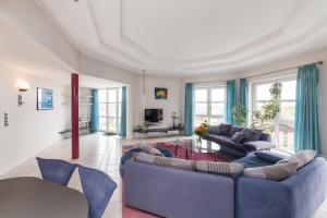 uma sala de estar com dois sofás azuis e uma mesa em Novum Hotel Strijewski - Apartments em Wolfsburg