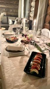 una mesa con un plato de sushi y copas de vino en Nilimukka en Levi
