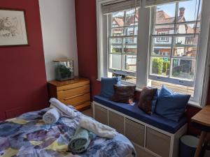 a bedroom with a bed and a window with a fish tank at Comfortable stylish room in Hanwell in Greenford
