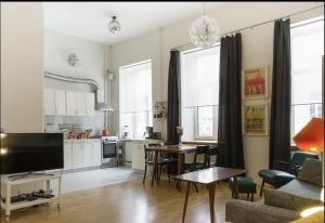 維爾紐斯的住宿－LOFT STYLE APARTMENT in the centre of VILNIUS，带沙发和桌子的客厅以及厨房。