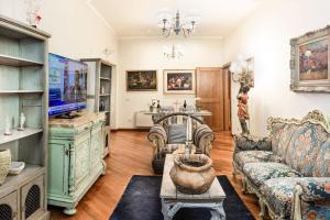 ein Wohnzimmer mit einem Sofa und einem TV in der Unterkunft Sansedoni - Luxury in Siena