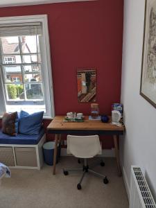 a room with a desk and a bed and a table at Comfortable stylish room in Hanwell in Greenford