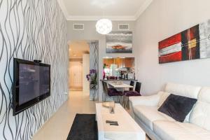 sala de estar con sofá blanco y TV en Holiday Home near beach & metro en Dubái