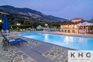a large swimming pool with chairs and a building at Jovanna Studios in the nature with Pool! in Trapezaki