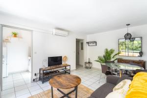 un salon avec un canapé et une télévision dans l'établissement La Castillane - Appt avec piscine partagée, à Cavalaire-sur-Mer