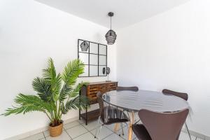 une salle à manger avec une table et une plante dans l'établissement La Castillane - Appt avec piscine partagée, à Cavalaire-sur-Mer