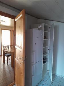 einen weißen Kühlschrank in einem Zimmer mit einem Tisch in der Unterkunft 2 bedroom 1 bath apartment in Kruså