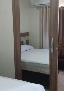 a reflection of a bedroom with a bed in a mirror at Villa Medici lacqua II in Caldas Novas +15 photos