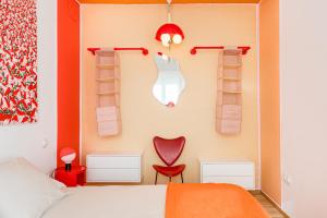 a bedroom with a bed and a red chair and shelves at Pop-Zen Penthouse Madrid in Madrid