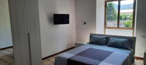 una camera da letto con un letto e una TV a parete di Ferry House a La Spezia