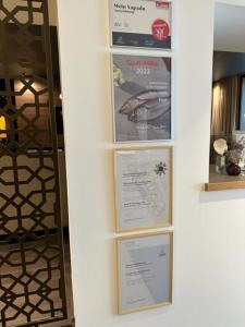 een muur met vier boekenplanken met posters erop bij Hotel Wirtshaus Post in Sankt Johann in Tirol