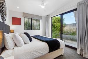 a bedroom with a large bed and a large window at Amazing Western Springs position in Auckland