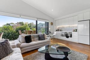 a living room with a couch and a table at Amazing Western Springs position in Auckland
