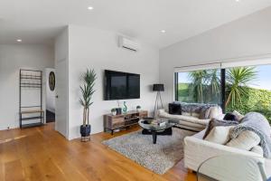 a living room with two couches and a tv at Amazing Western Springs position in Auckland