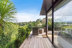 a house with a wooden deck with glass doors at Amazing Western Springs position in Auckland