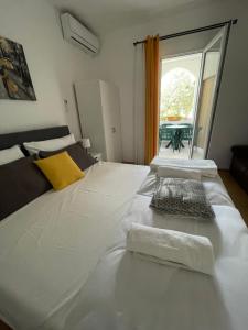 a large white bed in a room with a window at Apartmani Roko&Lovre Paklenica in Starigrad
