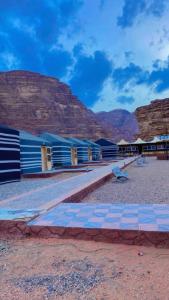 a blue building with a mountain in the background at Wadi rum Sunrise luxury camp in Wadi Rum