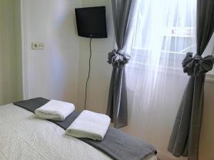 1 dormitorio con 1 cama con 2 toallas y una ventana en Apartamentos TravelStep La Latina, en Madrid