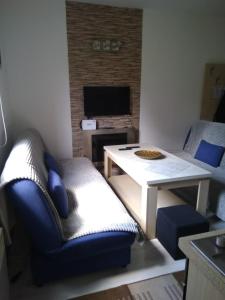 sala de estar con mesa y silla azul en Apartman Asja, en Vlašić