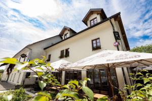 a white building with umbrellas in front of it at Pr'Finzgar in Brezje