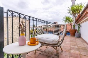 een balkon met een tafel, een stoel en een vaas bij Hotel Pop Alaçatı in Alacati