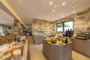 a large kitchen with a counter with fruit on it at Novum Hotel Strijewski - Apartments in Wolfsburg