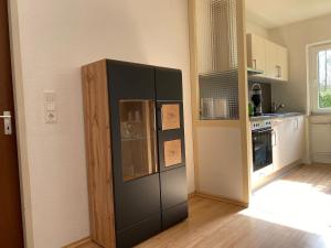 eine Küche mit einem großen schwarzen Kühlschrank in einem Zimmer in der Unterkunft Ferienwohnung Stiefelmühle in Sankt Ingbert