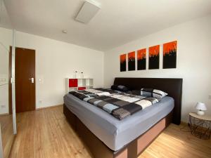 ein Schlafzimmer mit einem Bett und einige Gemälde an der Wand in der Unterkunft Ferienwohnung Stiefelmühle in Sankt Ingbert