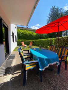 einem blauen Tisch mit Stühlen und einem roten Regenschirm in der Unterkunft Ferienwohnung Stiefelmühle in Sankt Ingbert