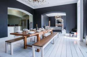une salle à manger avec une longue table en bois et des bancs dans l'établissement Pendine Manor - 9 Bedroom Manor House - Pendine, à Pendine