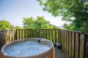 un bain à remous sur une terrasse avec une clôture en bois dans l'établissement Pendine Manor - 9 Bedroom Manor House - Pendine, à Pendine