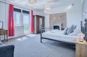 - une chambre avec un grand lit et une cheminée dans l'établissement Pendine Manor - 9 Bedroom Manor House - Pendine, à Pendine