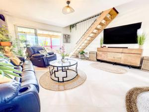 ein Wohnzimmer mit Couch und Fernseher in der Unterkunft Costa Rose, beach front, pool, Orient Bay in Orient Bay