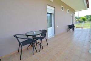 a patio with a table and chairs on a porch at Studios Λύδια in Paralía Skotínis